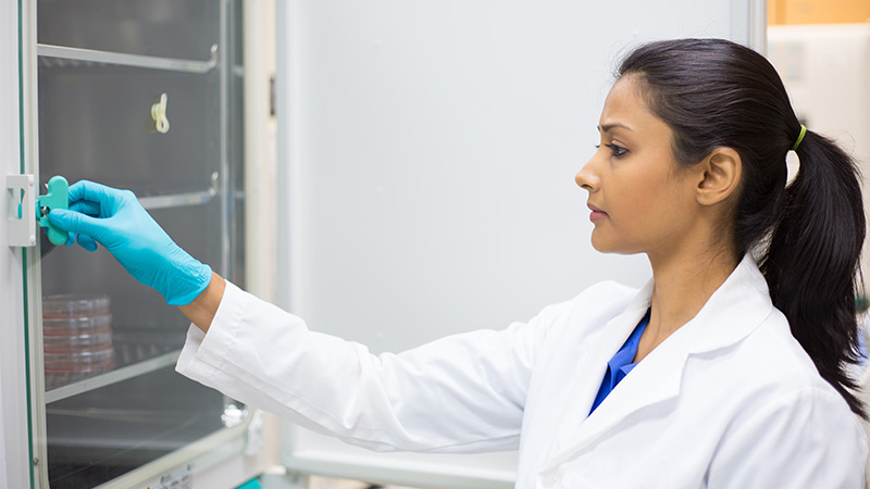 A woman in front of an incubator