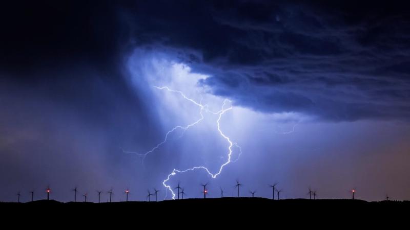 Storm and lightning bolts over windmills 