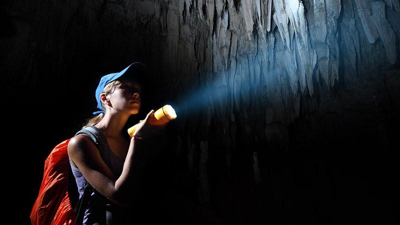 Woman in a cave with a torch
