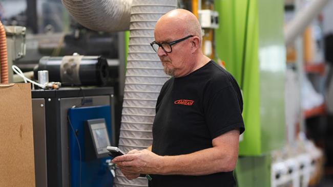 Camteam's Matti Majava using Vaisala Indigo80 handheld device for checking the moisture level of their plastics dryer