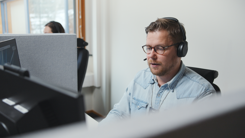 Customer support agent sitting at desk with headset on.