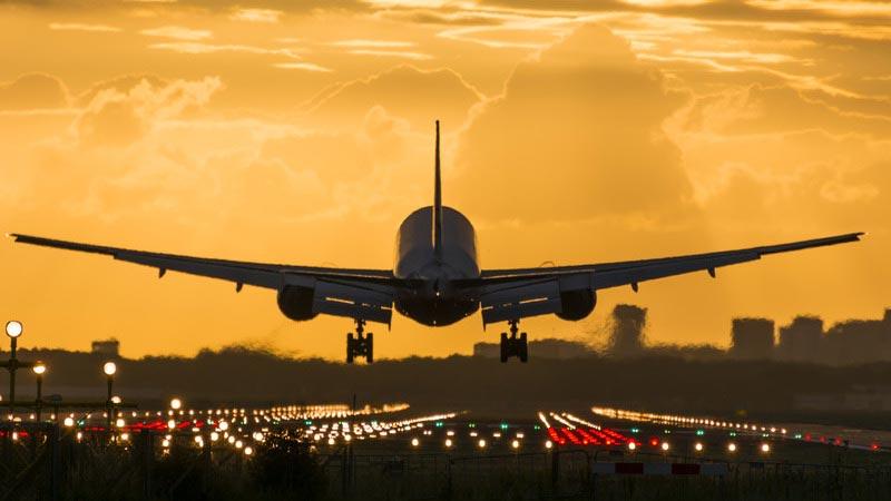 Plane about to touch down on the runway, engine heat and yellow sky